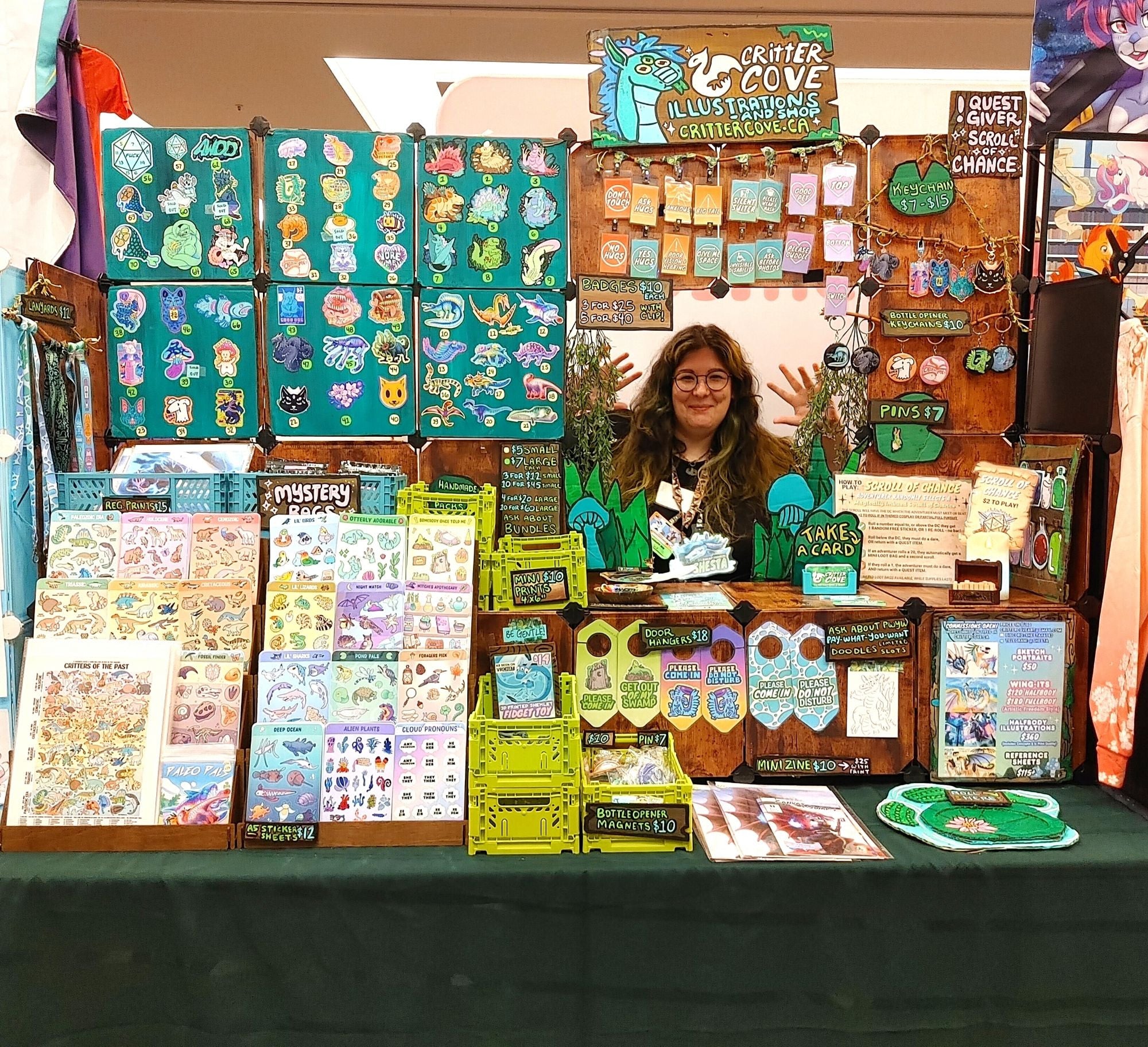 Person behind a display of illustrated books and art at a booth.